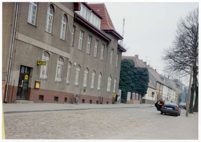 Fotografie. Außenansicht des Postgebäudes der Deutschen Bundespost in Templin, Puschinstraße 17, mit Leuchtschild als Wandausleger