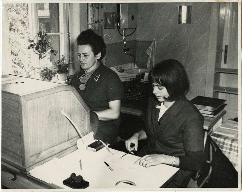 Fotografie. Zwei Mitarbeiterinnen der Deutschen Post der DDR in der Endtelegrafenstelle Klötze/Altmark bei der Bedienung eines  Fernschreibers und Aufkleben des Telegrammtextets auf ein Telegrammformular