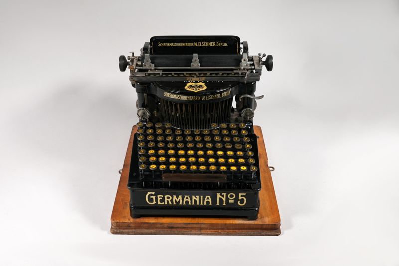 Mechanische Schreibmaschine Germania No. 5 (Germania / 5), auf Grundplatte mit Haube aus Blech