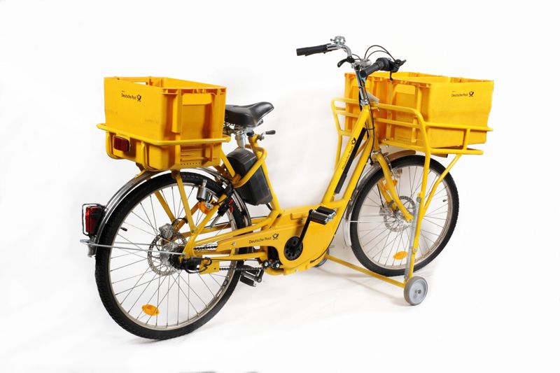 Fahrrad mit Elektromotor (Elektrobike) für Zusteller der Deutschen Post AG mit zwei Gepäckträgern, drei Postbehältern und einem Batterieladegerät im Auslieferungszustand