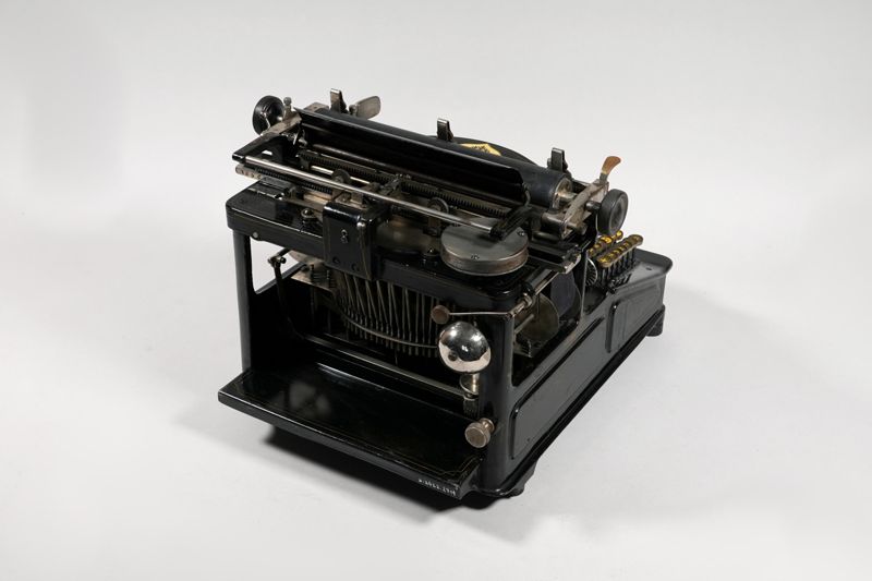 Mechanische Schreibmaschine Germania No. 5 (Germania / 5), auf Grundplatte mit Haube aus Blech