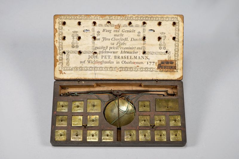 Waage, Münzwaage mit Gewichten für verschiedene Münzen und Währungen in Holzetui